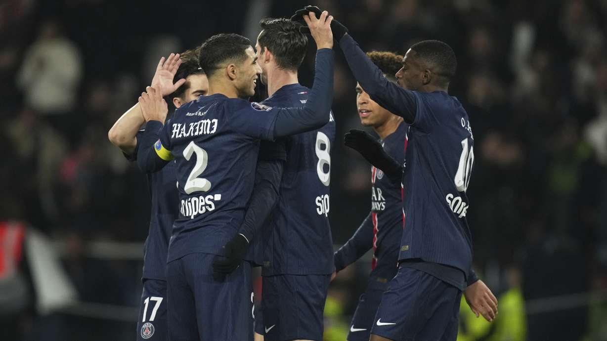 PSG's players celebrate after PSG's Nuno Mendes scored his side's second goal during the French League One soccer match between Paris Saint Germain and Marseille at Parc des Princes stadium in Paris, Sunday, March 16, 2025.