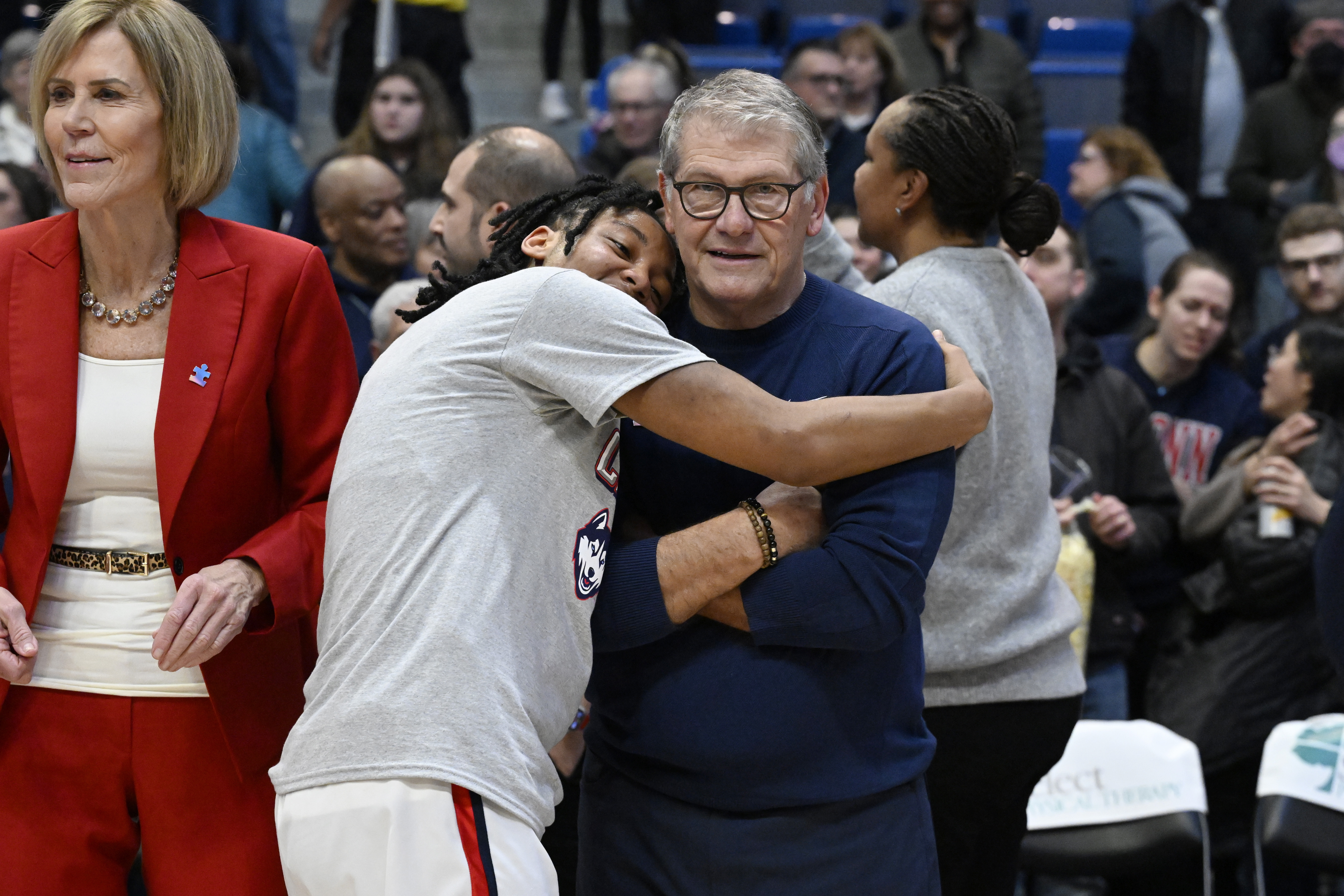 UConn head coach Geno Auriemma receives a hug from UConn guard KK Arnold as the team celebrates becoming Big East regular season champions after their win in an NCAA college basketball game against Creighton, Thursday, Feb. 27, 2025, in Hartford, Conn.