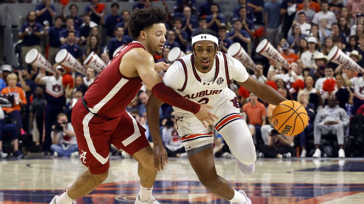 Auburn guard Denver Jones (2) dribbles around Alabama guard Mark Sears (1) during the second half of an NCAA college basketball game, Saturday, March 8, 2025, in Auburn, Ala.