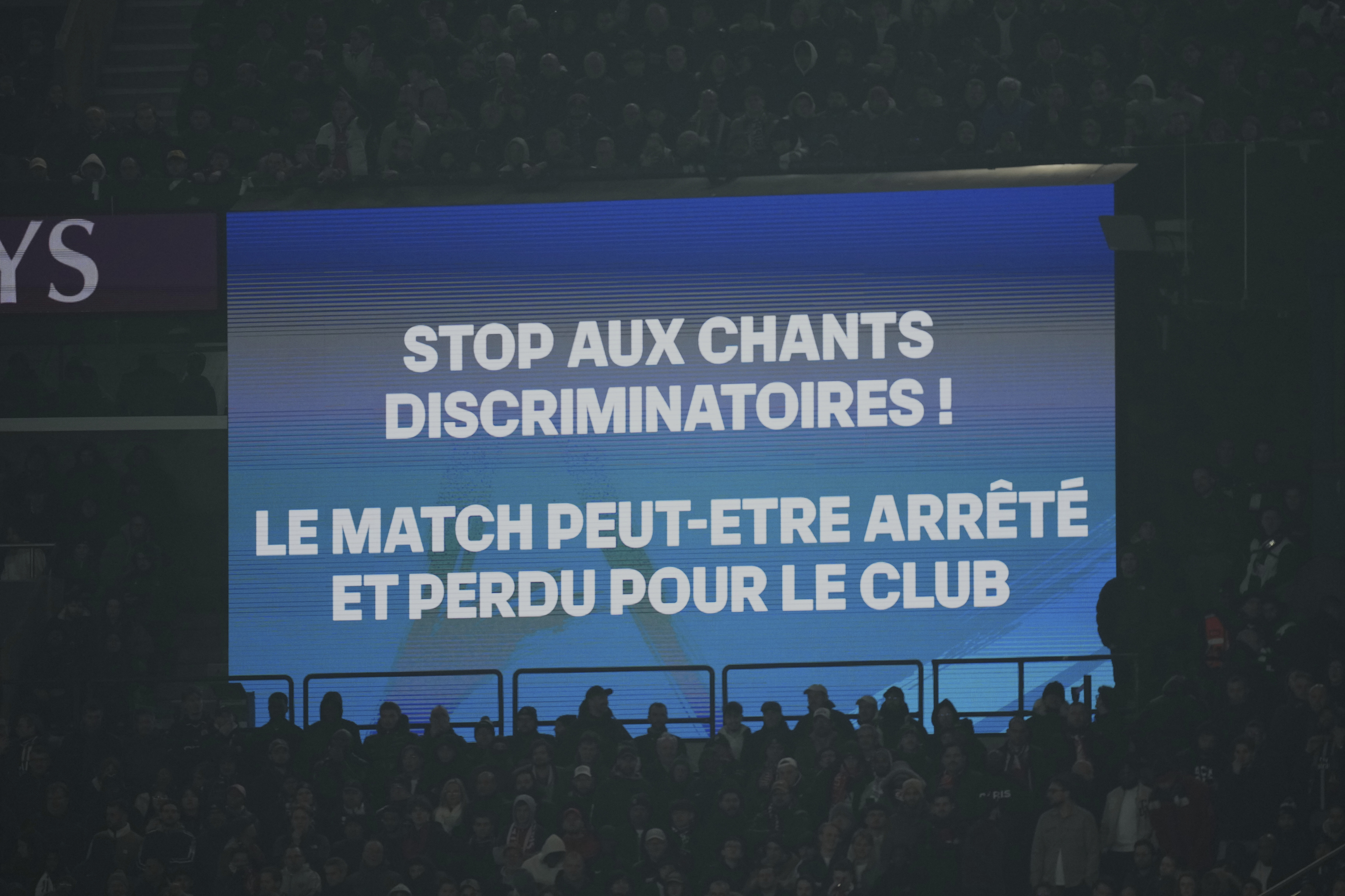 A giant screen shows a write "stop discriminatory chants - the match can be stopped and lost for the club" during the French League One soccer match between Paris Saint Germain and Marseille at Parc des Princes stadium in Paris, Sunday, March 16, 2025.
