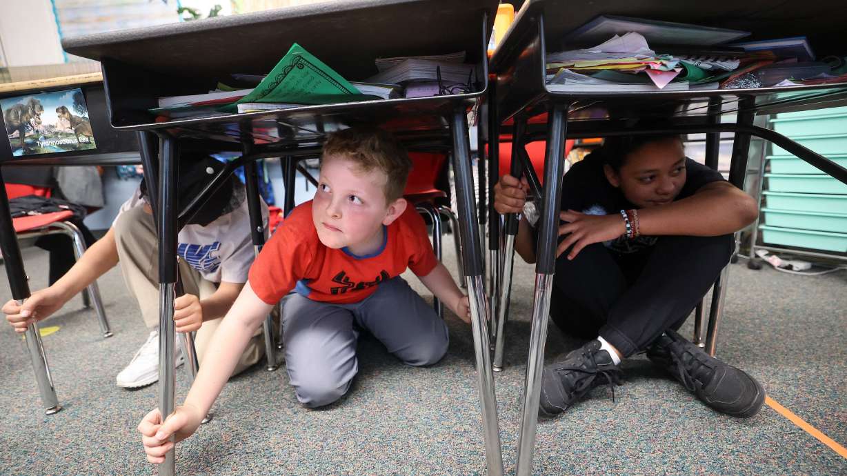 Fourth graders Jose Gonzalez, Austin Russ and Aaliyah Genao practice taking cover under their desks for an earthquake drill at Heartland Elementary School in West Jordan on April 18, 2024. It's the five-year anniversary of the 2020 Magna earthquake.