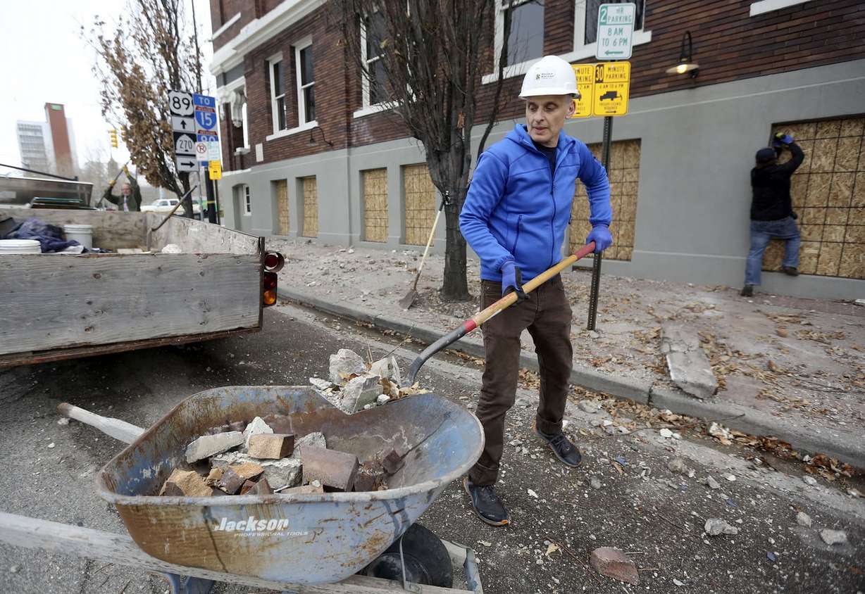 Paul Foster, a server at Caffé Molise, shovels debris that fell from the building in Salt Lake City after a 5.7 magnitude earthquake centered in Magna hit early March 18, 2020.