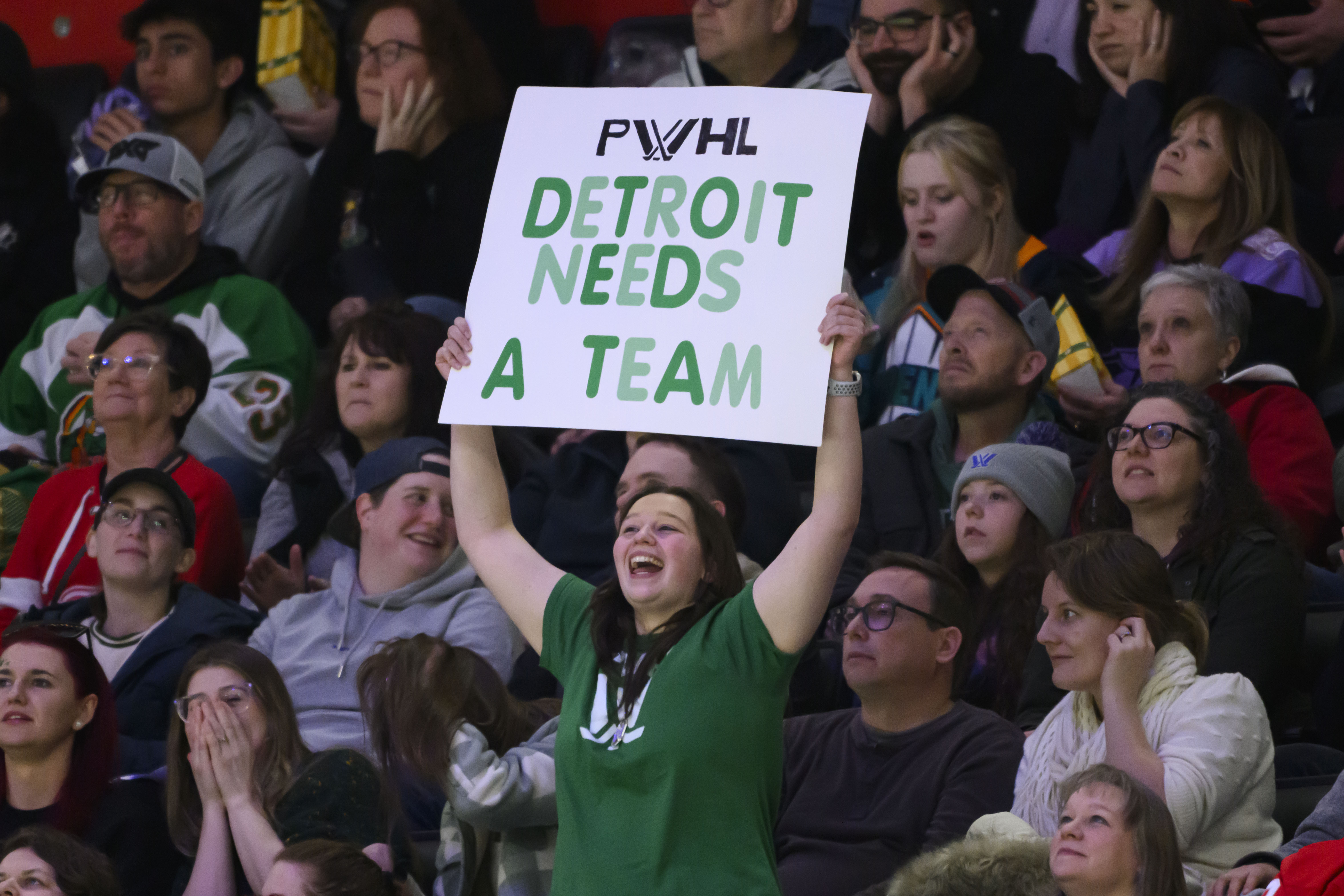 A fan holds up a sign indicating a desire for Detroit to get a PWHL team during the second period of a PWHL game between the New York Sirens and the Minnesota Frost, at Little Caesars Arena, in Detroit, Sunday, March 16, 2025.