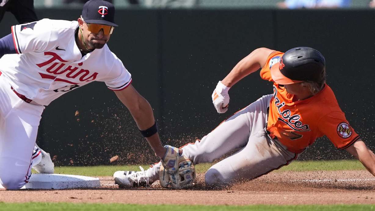 Baltimore Orioles Jackson Holliday is caught stealing third base by Minnesota Twins third baseman Royce Lewis in the first inning of a spring training baseball game in Fort Myers, Fla., Friday, Feb. 28, 2025.