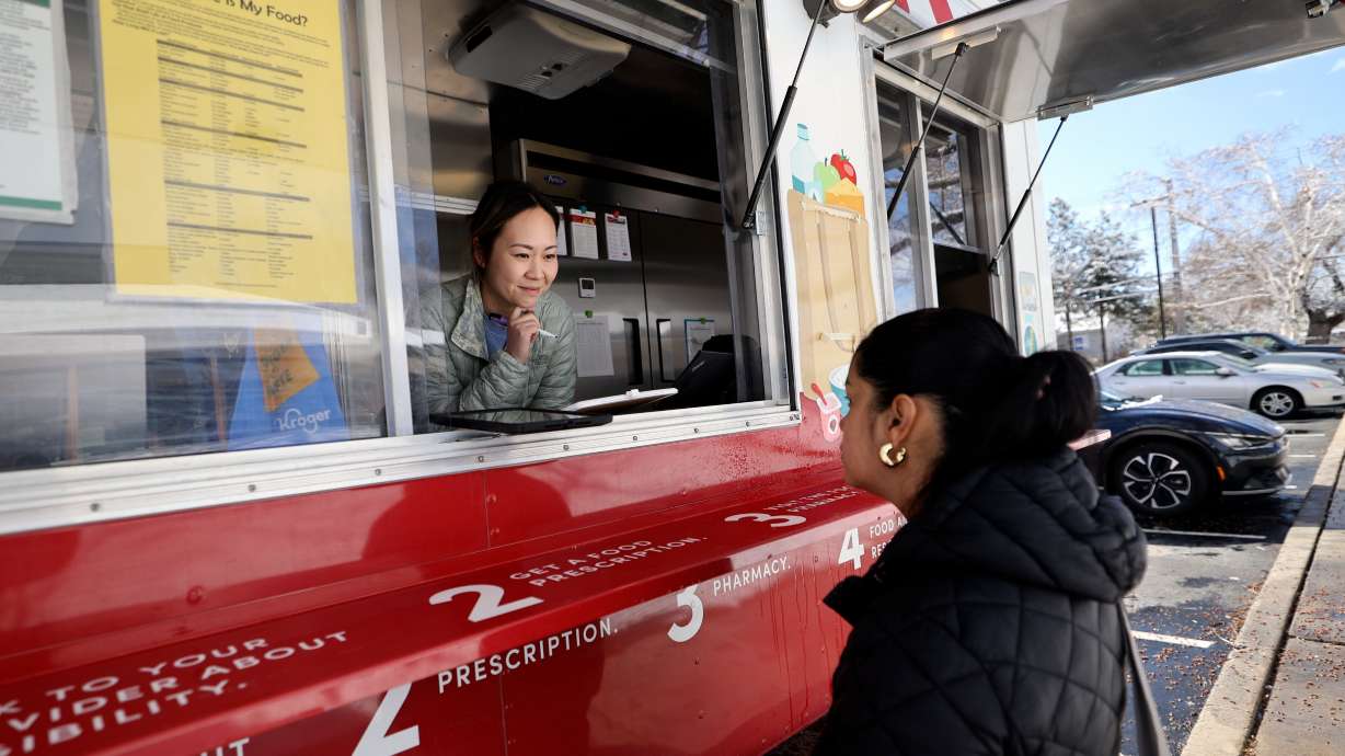 Sarah Zou, clinical dietician, talks to Alma Rivera, who is eight months pregnant and has gestational diabetes, about what food she would like from the University of Utah Health Food Pharmacy trailer in Midvale on Friday.