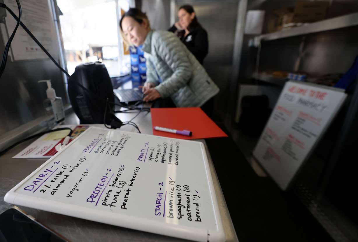 Sarah Zou, clinical dietician, helps a patient choose groceries at the University of Utah Health Food Pharmacy trailer parked outside of Greenwood Health Center in Midvale on Friday.