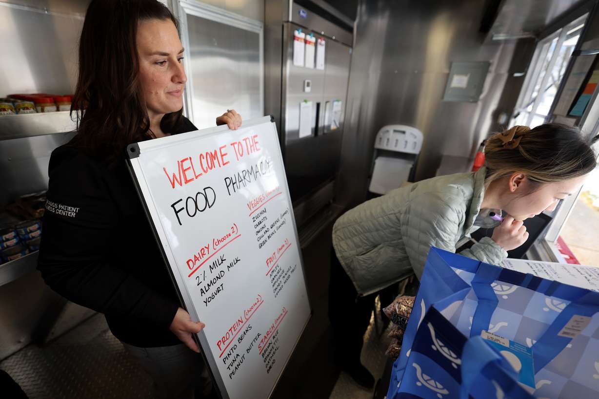 Ellen Maxfield, University of Utah Health clinical operations associate director, and Sarah Zou, clinical dietician, help a patient choose food from the University of Utah Health Food Pharmacy trailer parked outside of Greenwood Health Center in Midvale on Friday.