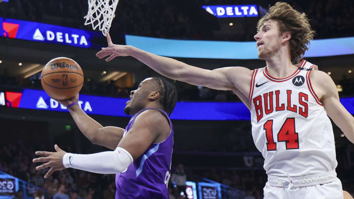 Utah Jazz guard Isaiah Collier, left, lays the ball up against Chicago Bulls forward Matas Buzelis (14) during the first half of an NBA basketball game, Monday, March 17, 2025, in Salt Lake City.