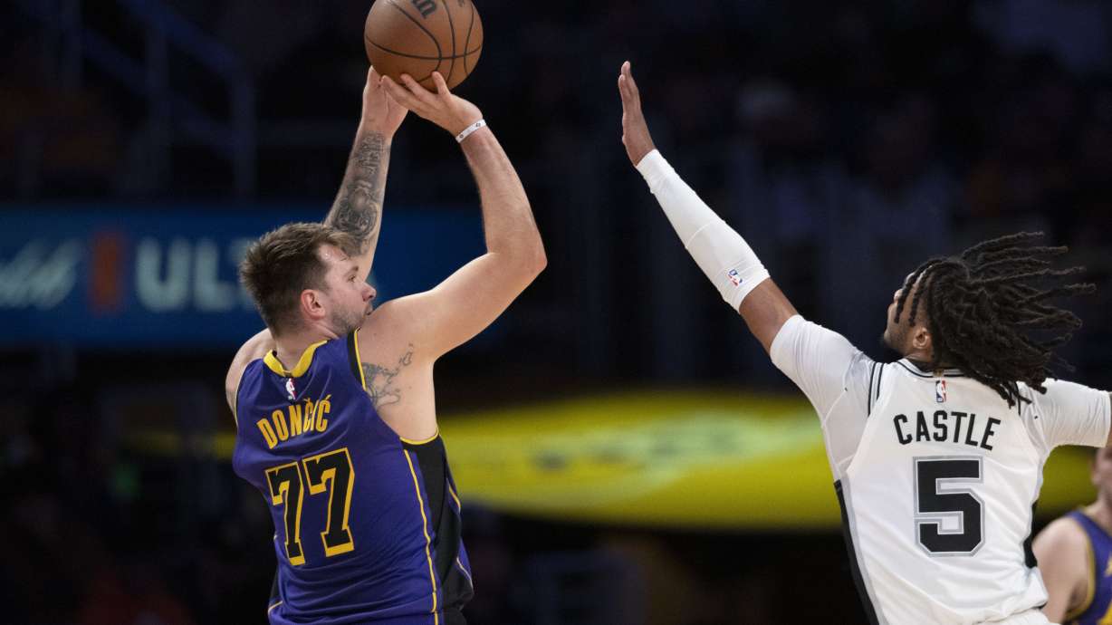 Los Angeles Lakers guard Luka Doncic (77) shoots over San Antonio Spurs guard Stephon Castle (5) during the first half of an NBA basketball game in Los Angeles, Monday, March 17, 2025.