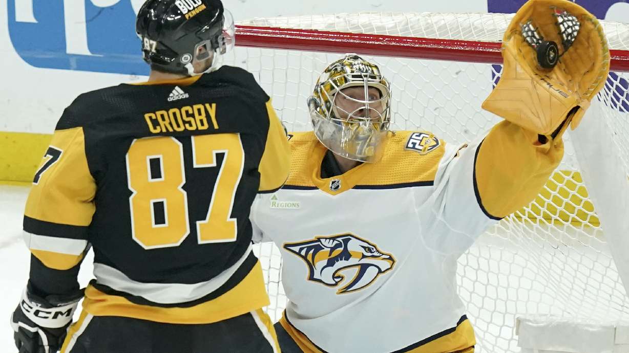 FILE - Nashville Predators goaltender Juuse Saros, right, makes a save in front of Pittsburgh Penguins' Sidney Crosby (87) during the first period of an NHL hockey game, April 15, 2024, in Pittsburgh.