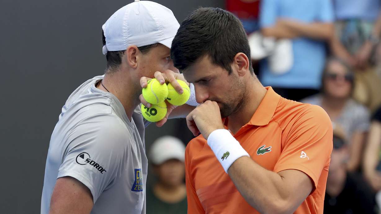 FILE - Canada's Vasek Pospisil and Serbia's Novak Djokovic talk tactics during their double match against during their Round of 32 match at the Adelaide International Tennis tournament in Adelaide, Australia, Jan. 2, 2023.
