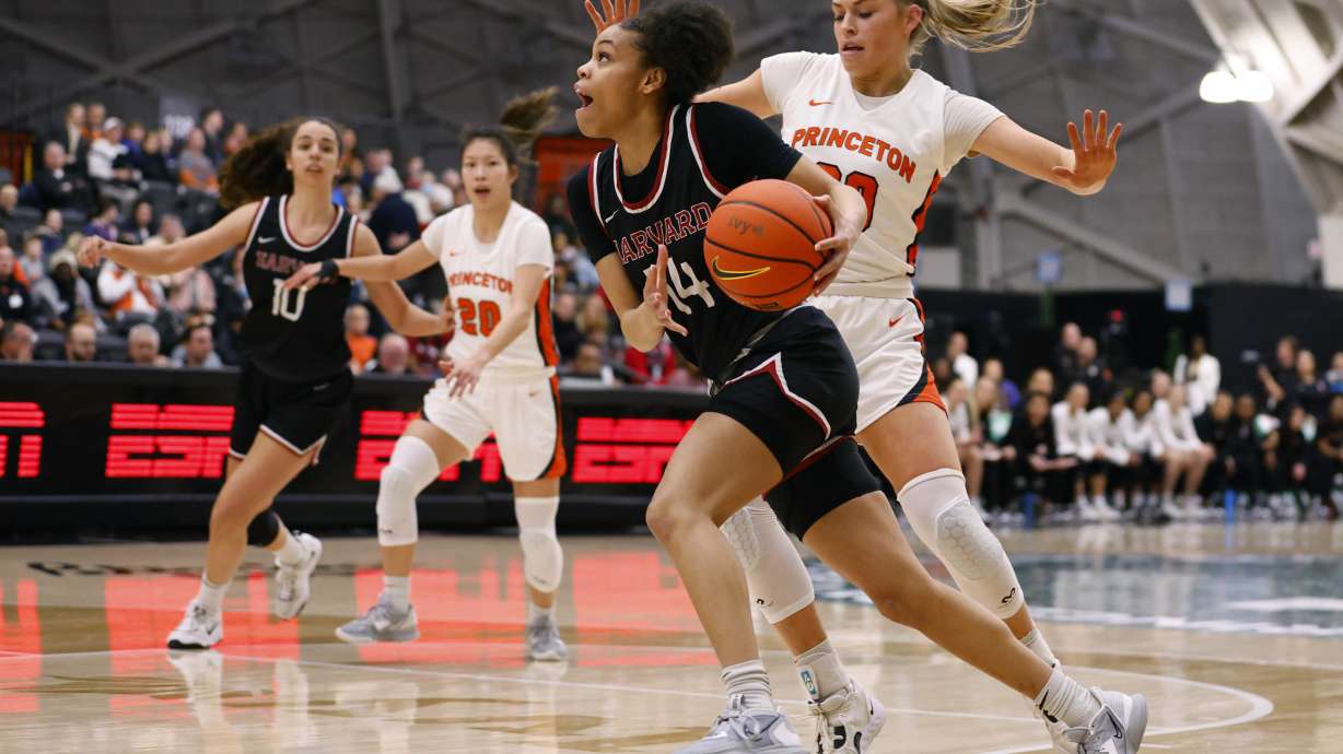 FILE - Harvard guard Harmoni Turner (14) drives to the basket against Princeton forward Ellie Mitchell (00) during the first half of the Ivy League championship NCAA college basketball game, Saturday, March 11, 2023, in Princeton, N.J.