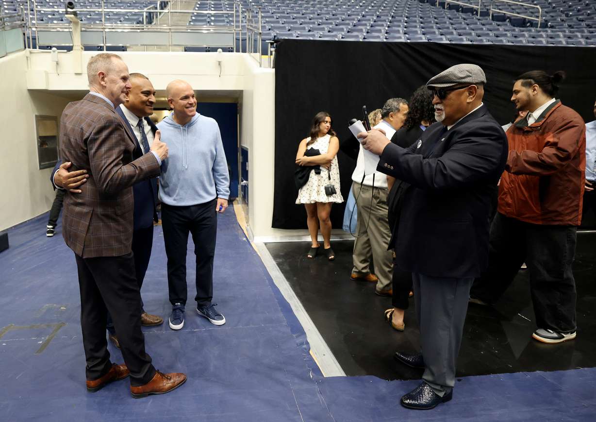 BYU athletic director Tom Holmoe, BYU football coach Kalani Sitake and BYU deputy athletic director Brian Santiago pose as Tom Sitake, Kalani’s father, takes a photo of them after Kalani Sitake’s devotional at the Marriott Center in Provo on Tuesday, March 11, 2025.