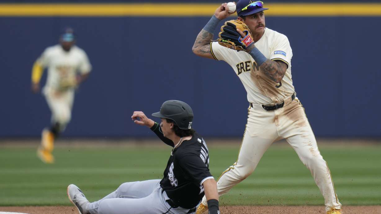 Milwaukee Brewers shortstop Joey Ortiz, right, holds the ball after forcing out Chicago White Sox's Brooks Baldwin, left, at second base during the fourth inning of a spring training baseball game Wednesday, March 5, 2025, in Phoenix.