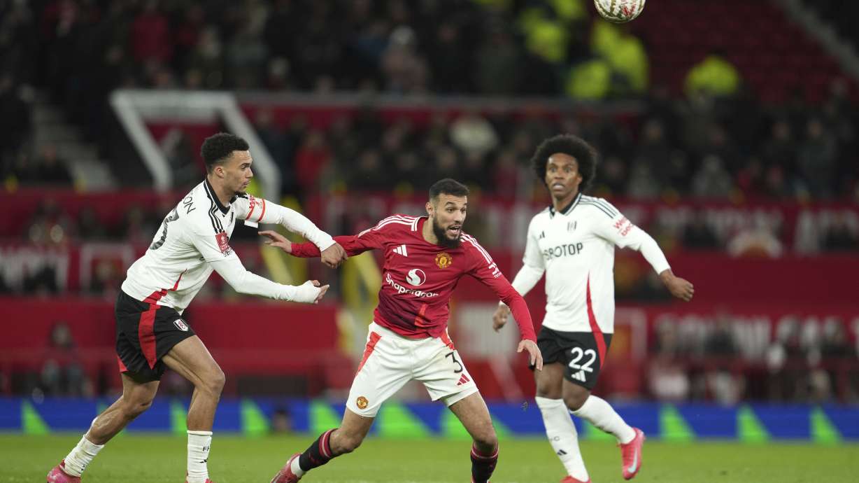 Fulham's Antonee Robinson, left, challenges for the ball with Manchester United's Noussair Mazraoui during the English FA Cup soccer match between Manchester United and Fulham at the Old Trafford stadium in Manchester, England, Sunday, March 2, 2025.