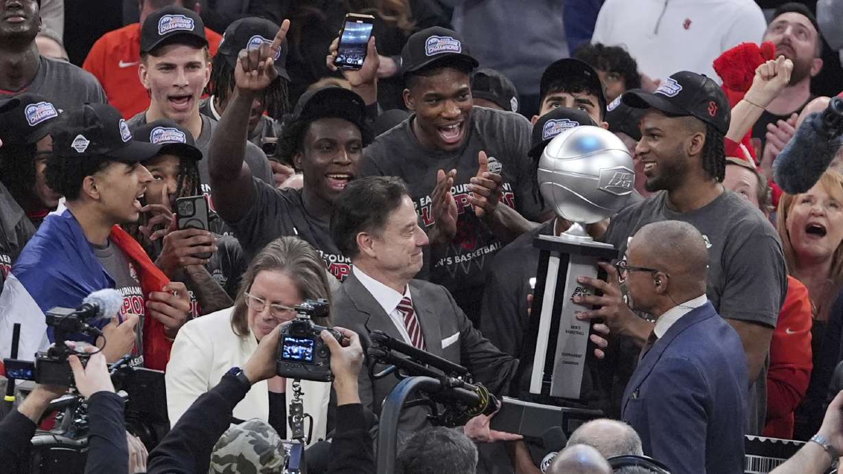 St. John's head coach Rick Pitino admires the tournment trophy after an NCAA college basketball game against Creighton in the championship of the Big East Conference tournament Saturday, March 15, 2025, in New York.