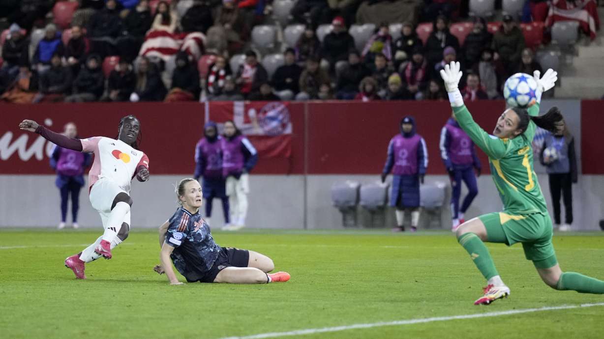 Lyon's Tabitha Chawinga, left, scores the opening goal past Bayern goalkeeper Maria-Luisa Grohs during the Women's Champions League quarterfinal first leg soccer match between FC Bayern Munich and Olympique Lyonnais at the FC Bayern Campus in Munich, Germany, Tuesday, March 18, 2025.