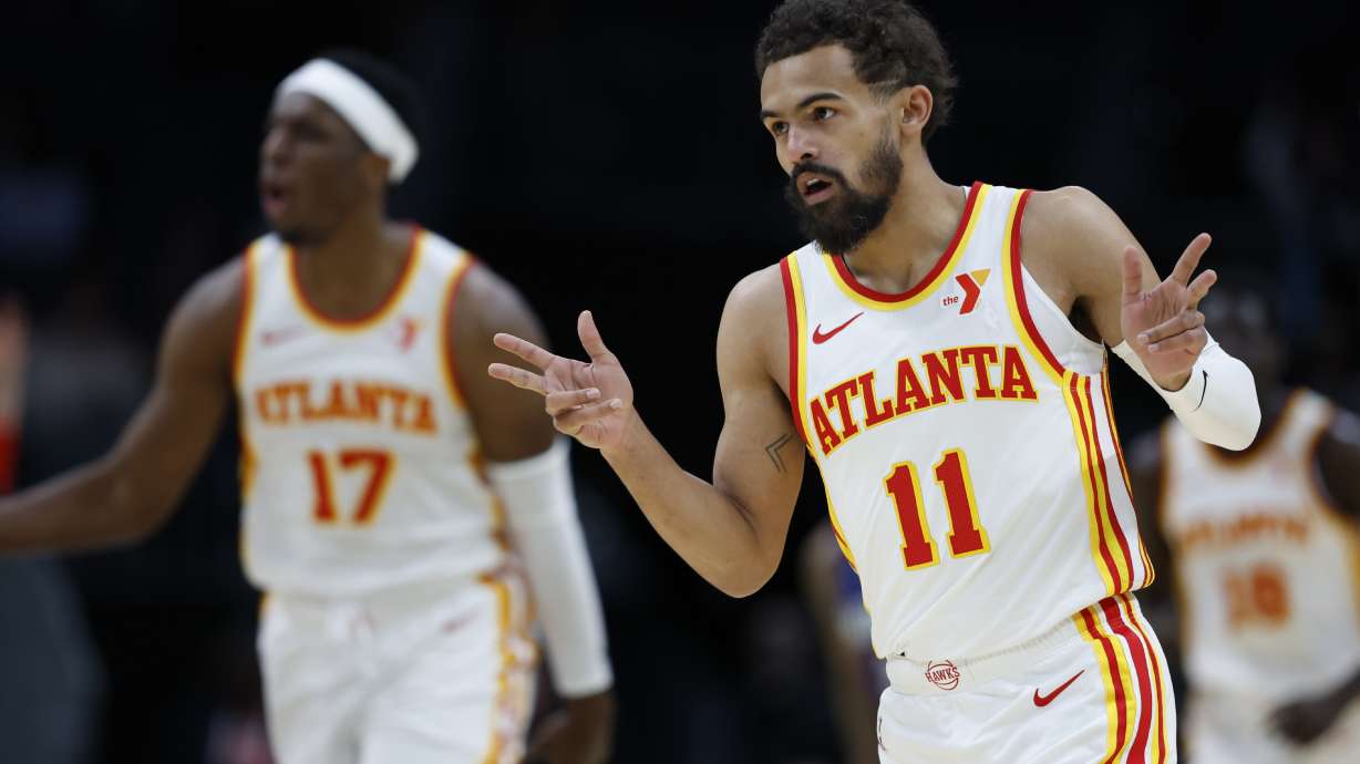 Atlanta Hawks guard Trae Young (11) gestures after making a three point basket against the Charlotte Hornets during the first half of an NBA basketball game in Charlotte, N.C., Tuesday, March 18, 2025.