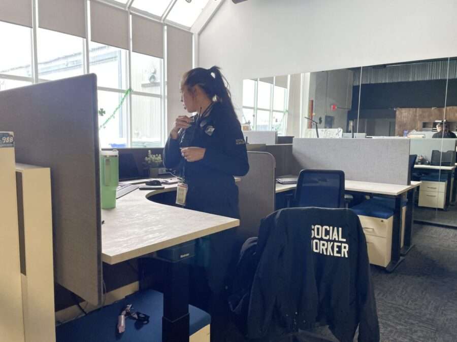 A Salt Lake City social worker answers a radio call at her desk in the Community Connection Team building.