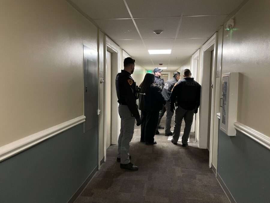 Social workers and officers deliver food to an individual who requested it.