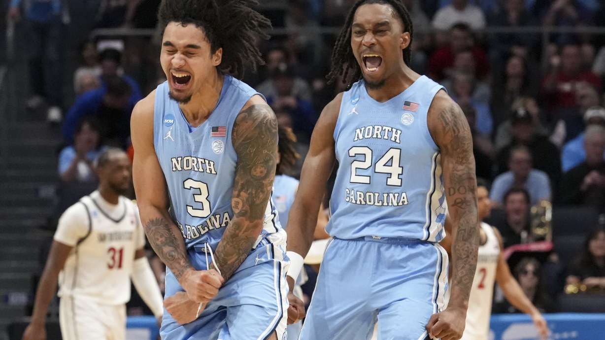 North Carolina's Elliot Cadeau (3) celebrates with teammate Jae'Lyn Withers (24) during the first half of a First Four college basketball game against San Diego State in the NCAA Tournament, Tuesday, March 18, 2025, in Dayton, Ohio.