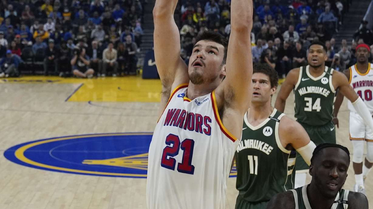 Golden State Warriors center Quinten Post (21) dunks next to Milwaukee Bucks forward Taurean Prince (12) during the first half of an NBA basketball game Tuesday, March 18, 2025, in San Francisco.