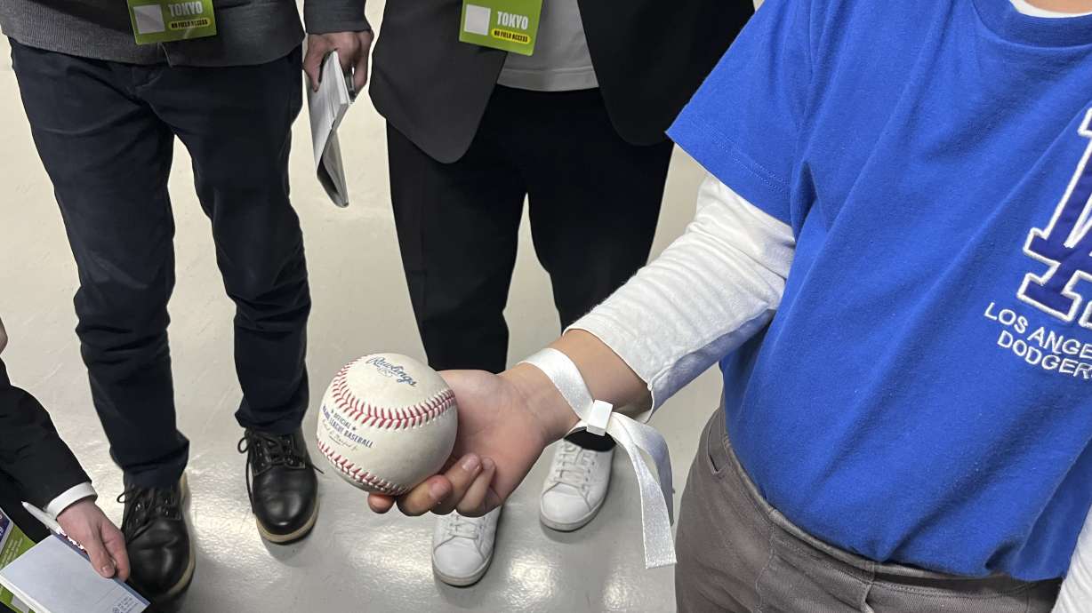 A 10-year-old boy who caught the home run ball hit by the Los Angeles' Shohei Ohtani, shows the ball to the media during an MLB Tokyo Series baseball game between the Dodgers and the Chicago Cubs at the Tokyo Dome in Tokyo, Wednesday, March 19, 2025.