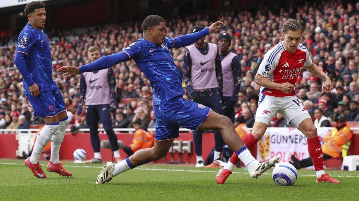 Chelsea's Wesley Fofana, centre, challenges for the ball with Arsenal's Leandro Trossard during the English Premier League soccer match between Arsenal and Chelsea at Emirates stadium in London, Sunday, March 16, 2025.