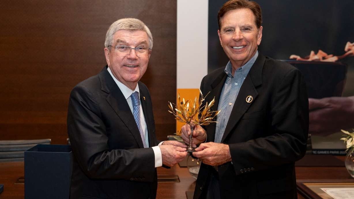 International Olympic Committee President Thomas Bach presents Fraser Bullock a sculpture representing the source of the olive laurels given to ancient Olympians in Costa Navarino, Greece.