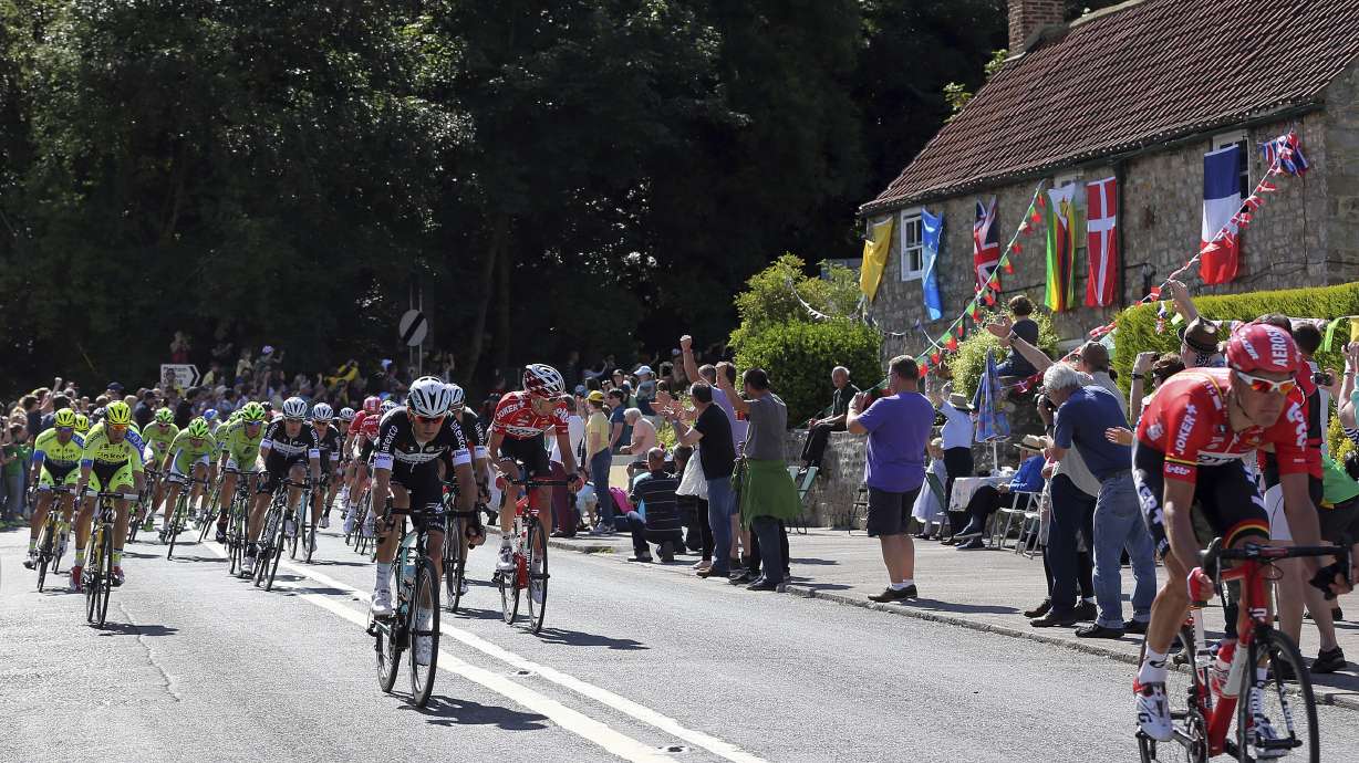 FILE - Tour De France riders cycle through the village of West Tanfield, England during the first stage of the race Saturday, July 5, 2014..