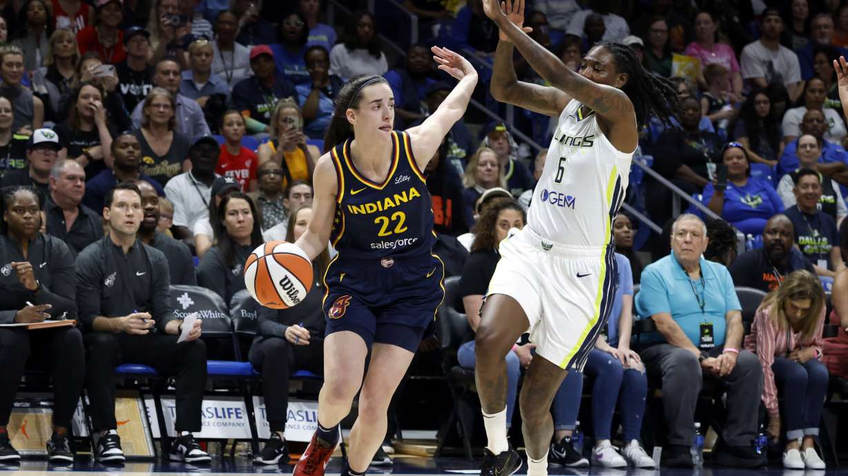FILE - Indiana Fever guard Caitlin Clark (22) drives past Dallas Wings forward Natasha Howard (6) during the first half of an WNBA basketball game in Arlington, Texas, May 3, 2024.