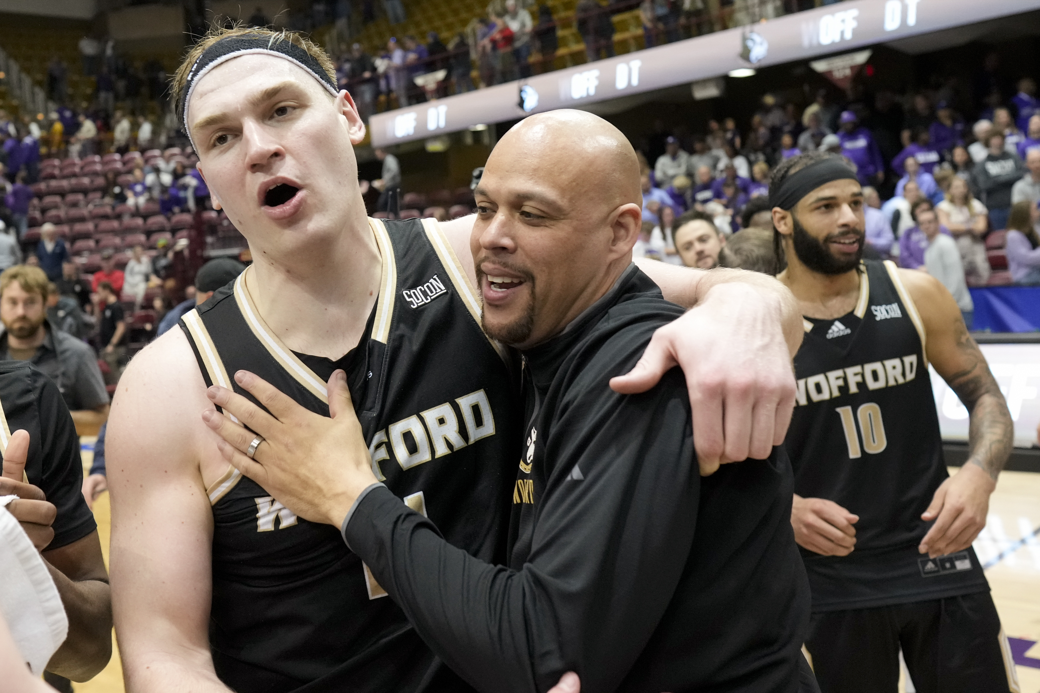 Wofford center Kyler Filewich celebrates with head coach Dwight Perry after their win against Furman in a college basketball championship game at the Southern Conference tournament, Monday, March 10, 2025, in Asheville, N.C.
