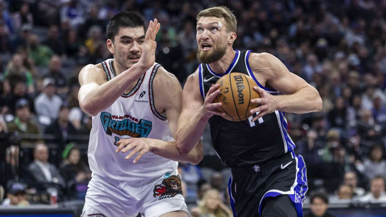 Sacramento Kings center Domantas Sabonis, right, makes a driving layup on Memphis Grizzlies center Zach Edey, left, during the first half of an NBA basketball game Monday, March 17, 2025, in Sacramento, Calif.