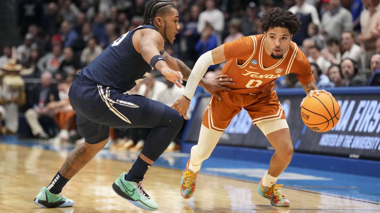 Texas guard Jordan Pope (0) drives against Xavier guard Dayvion McKnight during the first half of a First Four college basketball game in the NCAA Tournament, Wednesday, March 19, 2025, in Dayton, Ohio.