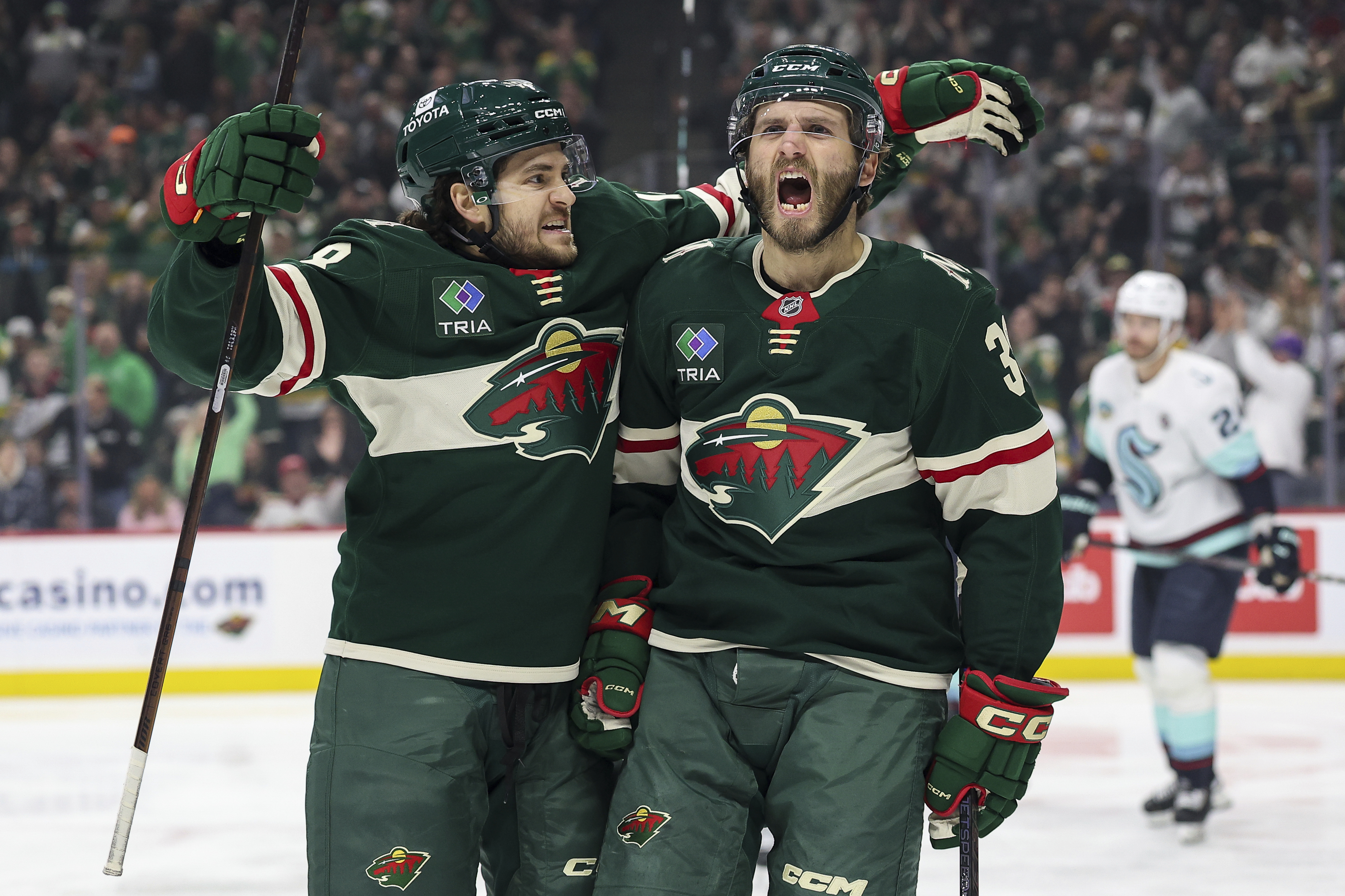Minnesota Wild right wing Ryan Hartman, right, celebrates his goal with center Vinnie Hinostroza during the first period of an NHL hockey game against the Seattle Kraken Wednesday, March 19, 2025, in St. Paul, Minn.