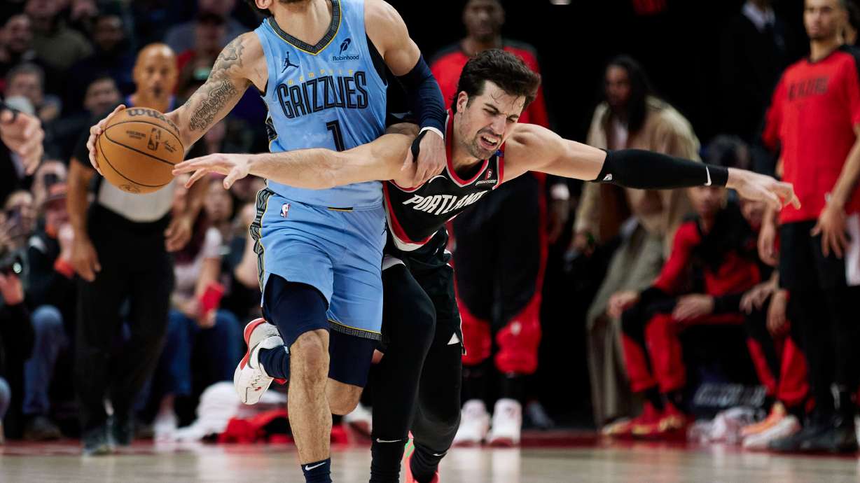 Memphis Grizzlies guard Scotty Pippen Jr., left, and Portland Trail Blazers forward Deni Avdija collide during the second half of an NBA basketball game in Portland, Ore., Wednesday, March 19, 2025.