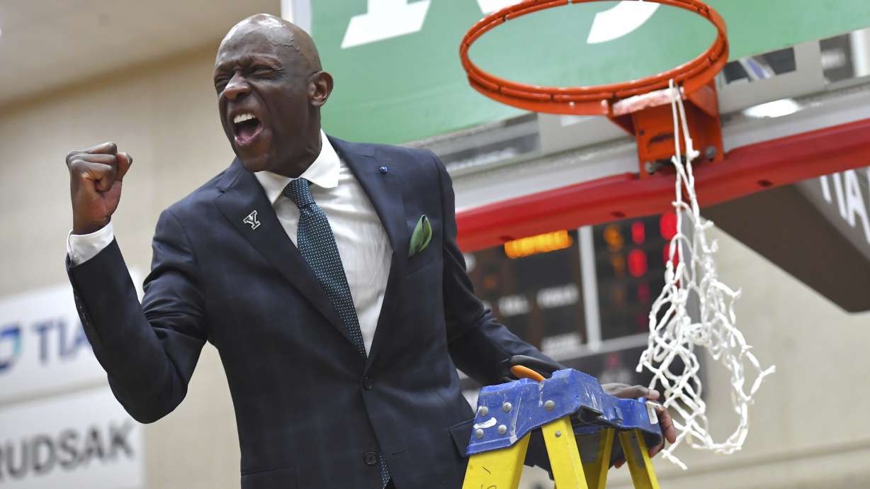 Yale head coach James Jones celebrates while helping to cut down the net after defeating Cornell in an Ivy League tournament championship NCAA college basketball game, Sunday, March 16, 2025, in Providence, R.I.