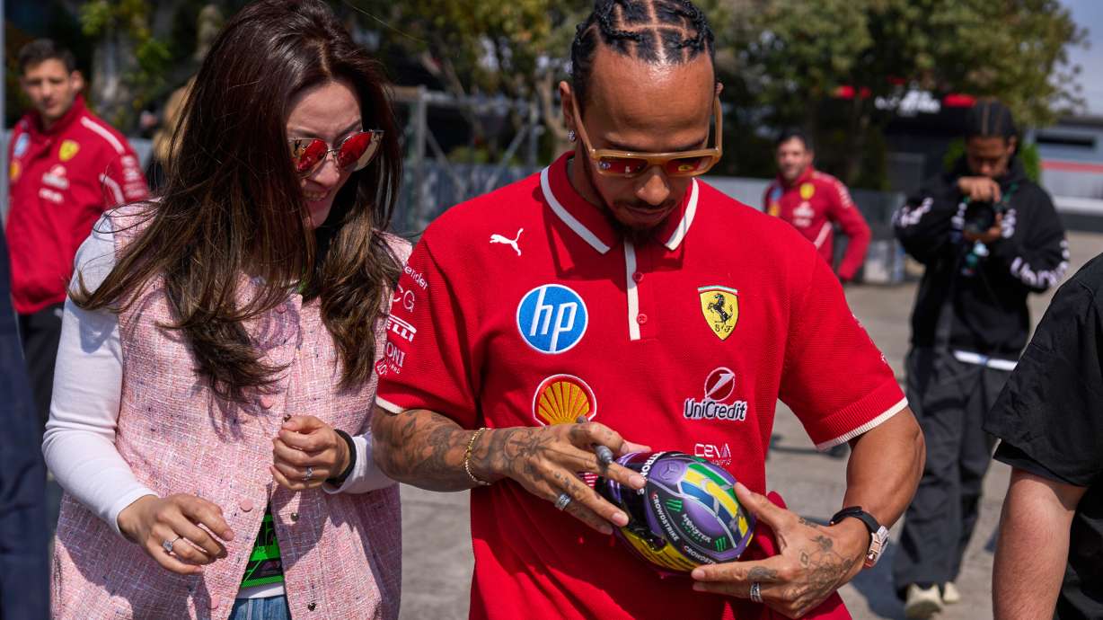 Ferrari driver Lewis Hamilton of Britain signs his autograph for a fan at the Shanghai International Circuit ahead of the Chinese Formula One Grand Prix, in Shanghai, China, Thursday, March 20, 2025.
