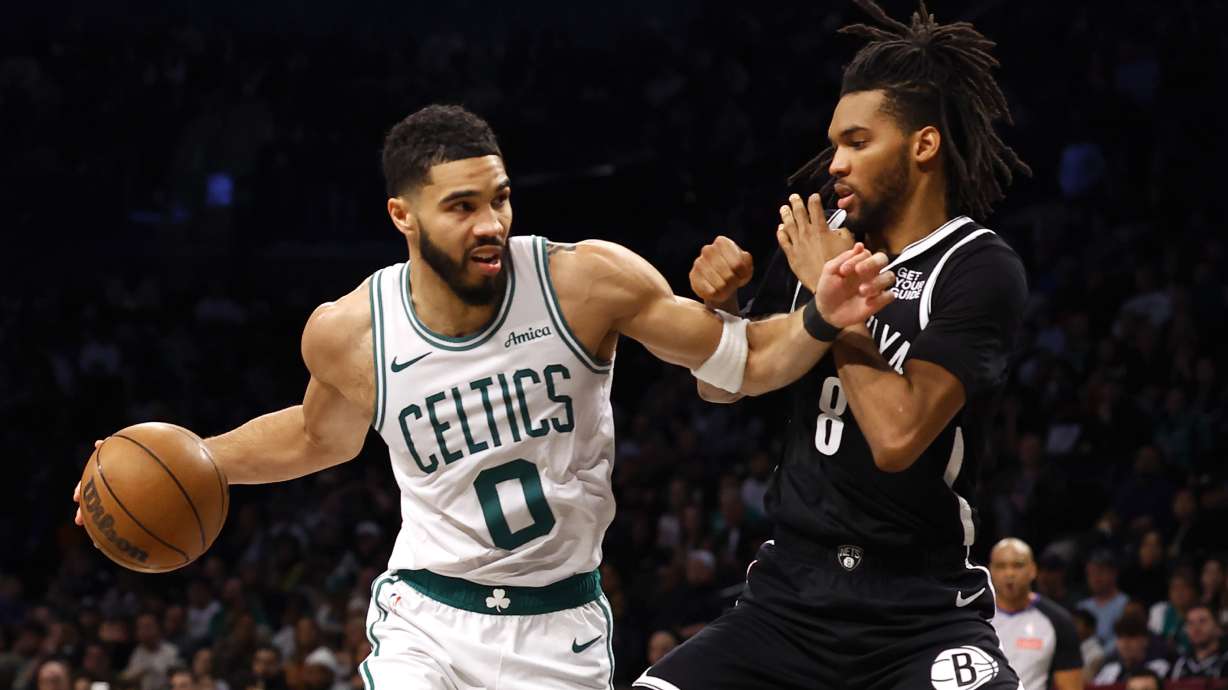 Boston Celtics forward Jayson Tatum (0) drives to the basket against Brooklyn Nets forward Ziaire Williams (8) during the first half of an NBA basketball game, Saturday, March 15, 2025, in New York.