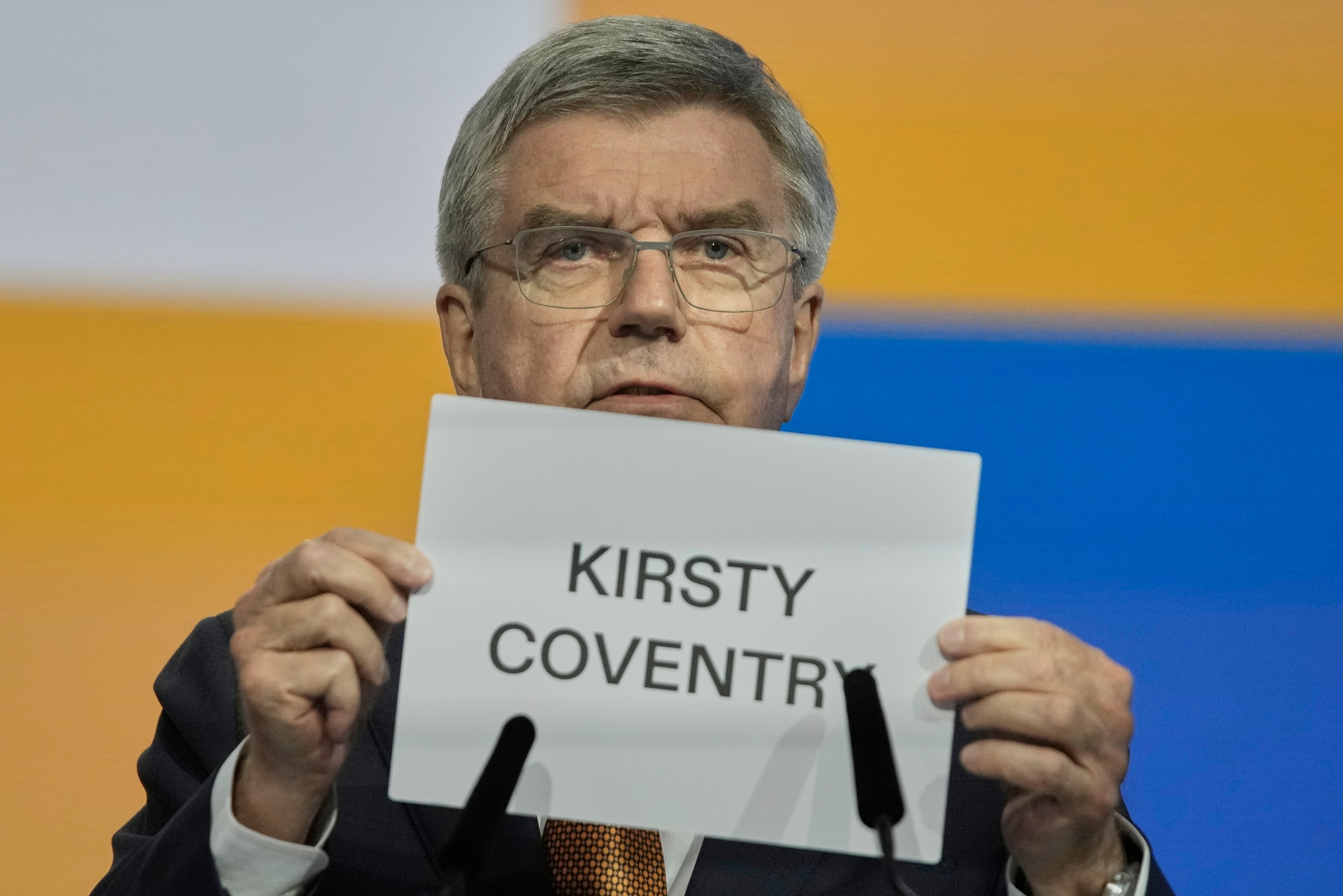 IOC President Thomas Bach holds up the name of Kirsty Coventry as she is announced as the new IOC president at the International Olympic Committee's 144th session in Costa Navarino, western Greece, Thursday, March 20.