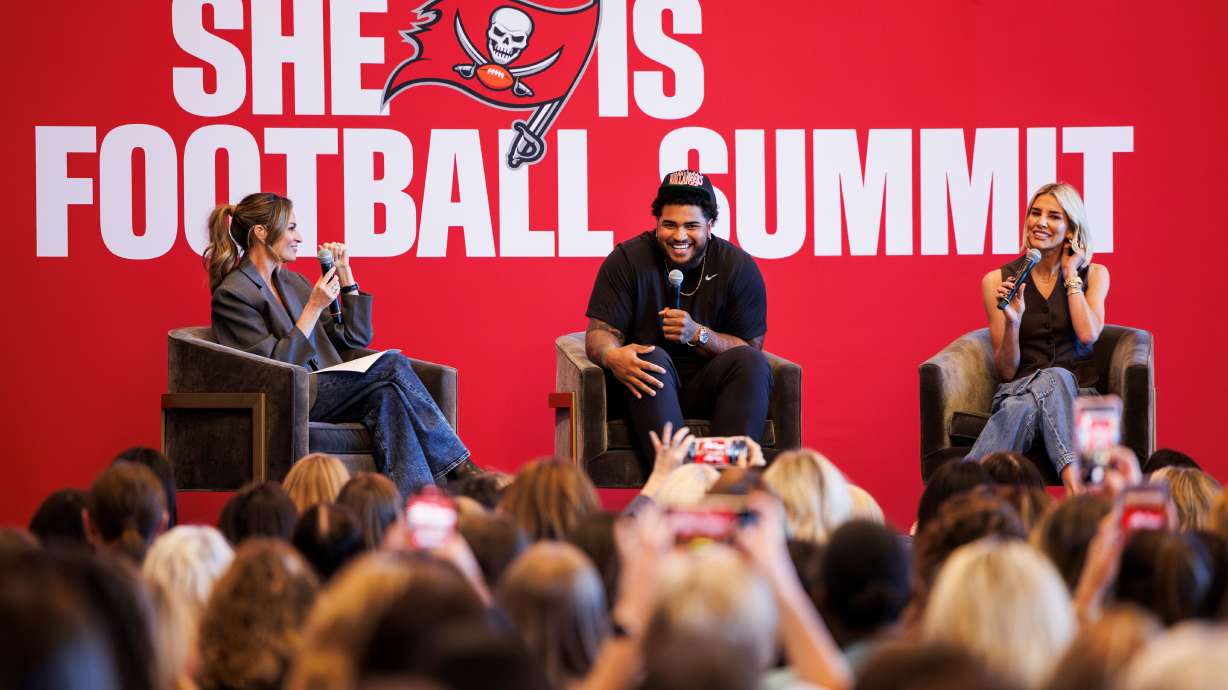 In this image provided by the Tampa Bay Buccaneers, Erin Andrews, left, and Charissa Thompson, right, record a live episode of "Calm Down with Erin and Charissa" with Tampa Bay Buccaneers' Tristan Wirfs during the inaugural She Is Football Summit, Friday, March 7, 2025, at Raymond James Stadium in Tampa.