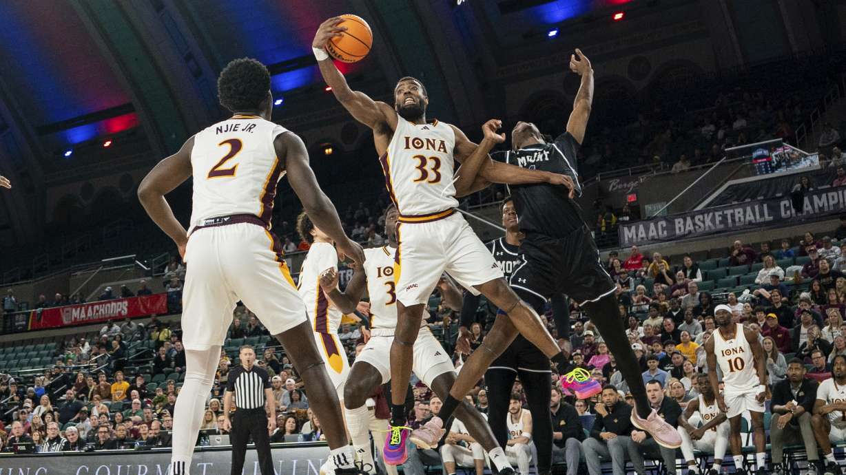 Iona's Jalen Barr, center, reaches for the rebound s he holds back Mount St. Mary's Dola Adebayo, right, during the first half of an NCAA college basketball game in the championship of the Metro Atlantic Athletic Conference tournament, Saturday, March 15, 2025, in Atlantic City, N.J.