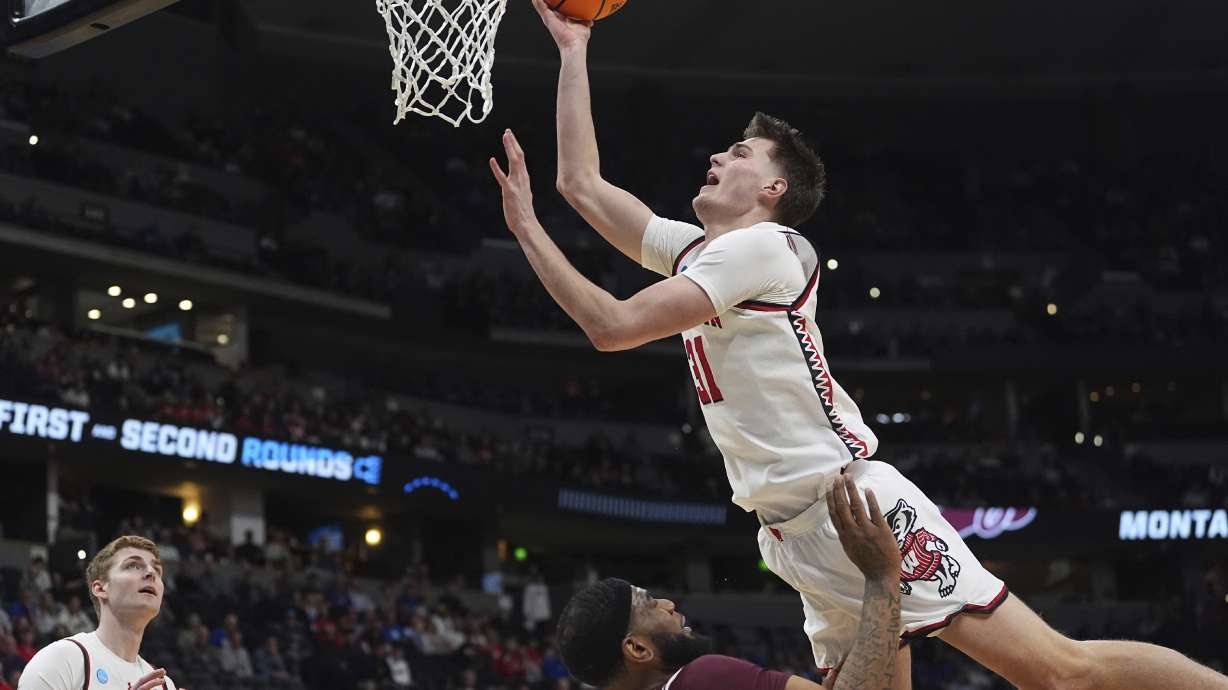 Wisconsin forward Nolan Winter, top, collides with Montana forward Te'Jon Sawyer while shooting during the first half in the first round of the NCAA college basketball tournament Thursday, March 20, 2025, in Denver.