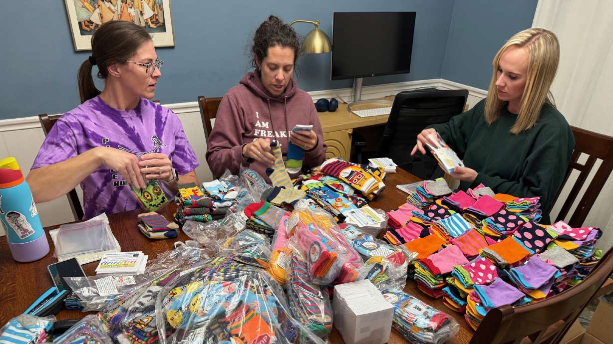 Kim Garrett and other women with children with Down syndrome sort socks for World Down Syndrome Day on Friday. The socks represent crazy chromosomes, like the triplication of the 21st chromosome indicates Down syndrome.