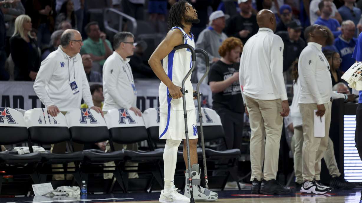 Memphis guard Tyrese Hunter (11) stands in a boot by the bench during the second half of an NCAA college basketball game against Tulane in the semifinals of the American Athletic Conference tournament, Saturday, March 15, 2025, in Fort Worth, Texas.