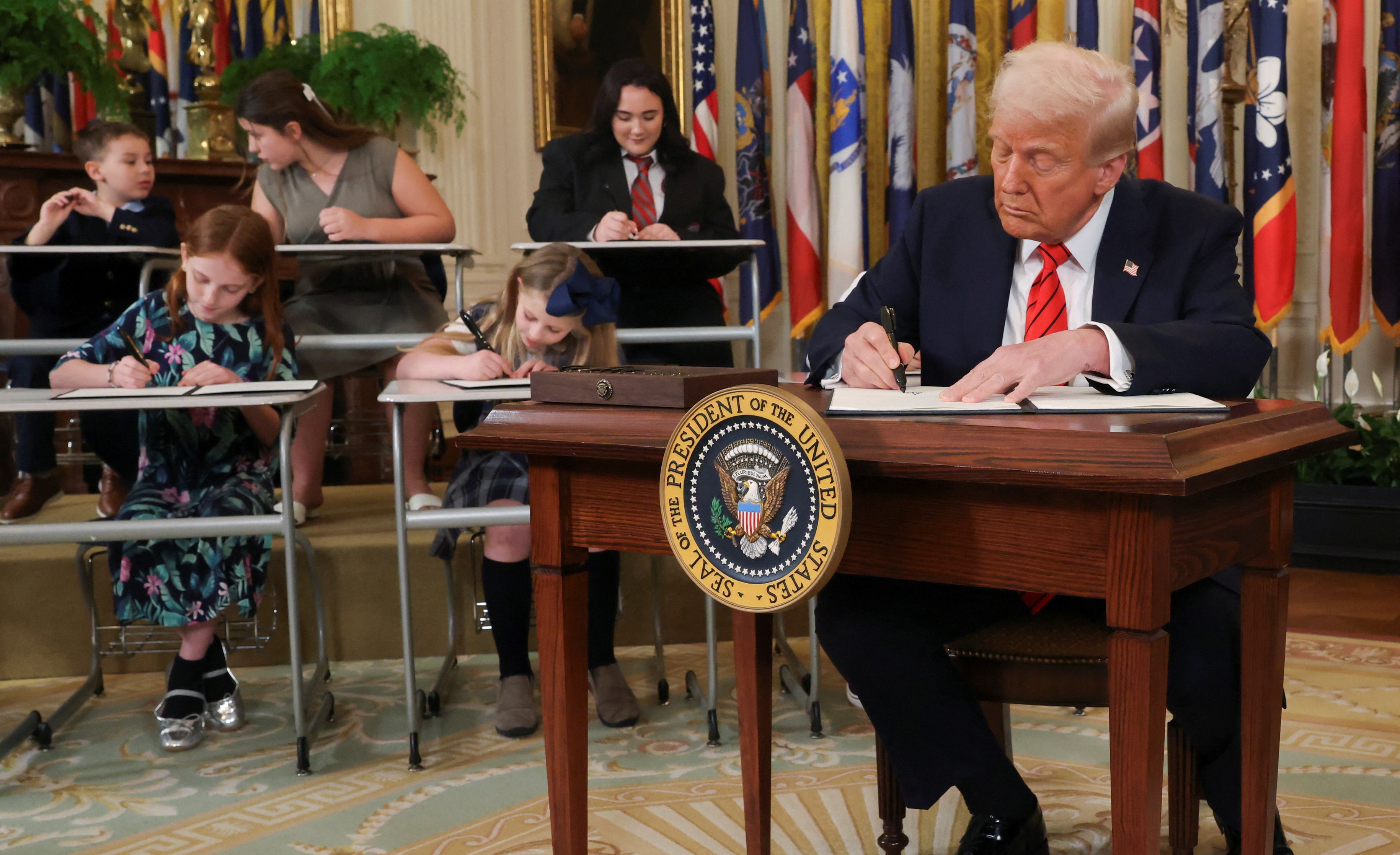 President Donald Trump signs an executive order to shut down the Department of Education, during an event in the East Room at the White House in Washington, Thursday.