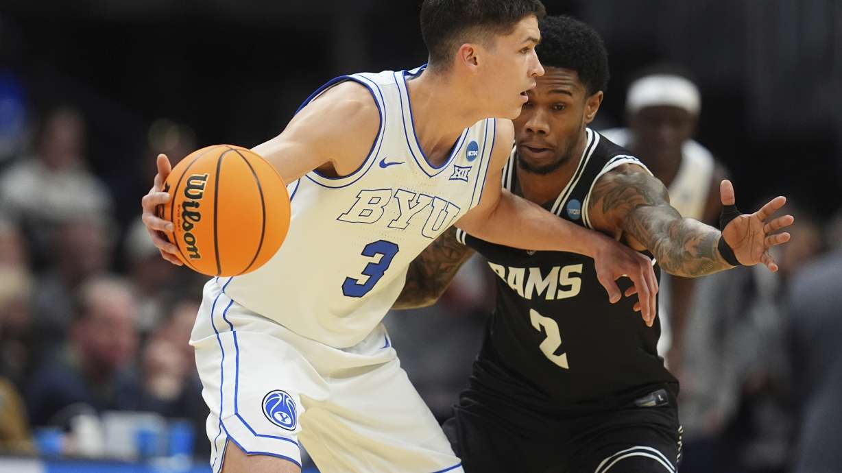 BYU guard Egor Demin, left, looks to pass the ball as Virginia Commonwealth guard Zeb Jackson defends during the first half in the first round of the NCAA college basketball tournament Thursday, March 20, 2025, in Denver.