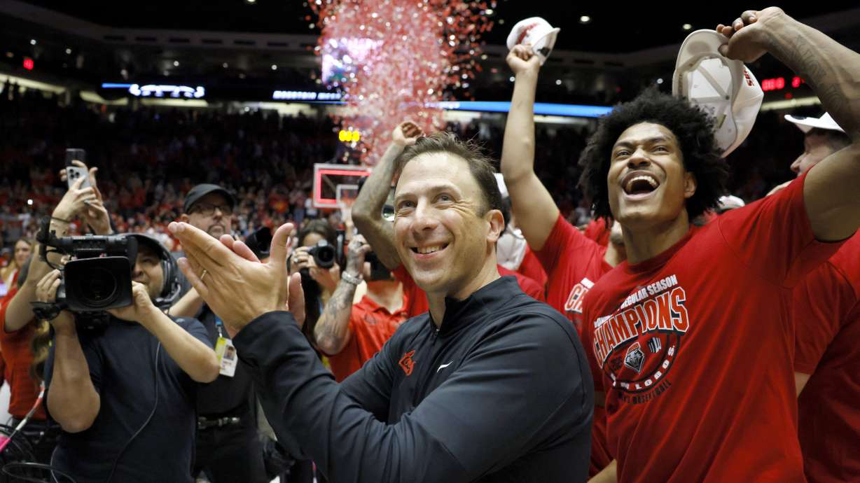 New Mexico Head coach Richard Pitino celebrates his team's Mountain West title after beating UNLV in an NCAA college basketball game, Friday, March 7, 2025, in Albuquerque, N.M. Also pictured, at right, is New Mexico guard Tru Washington.