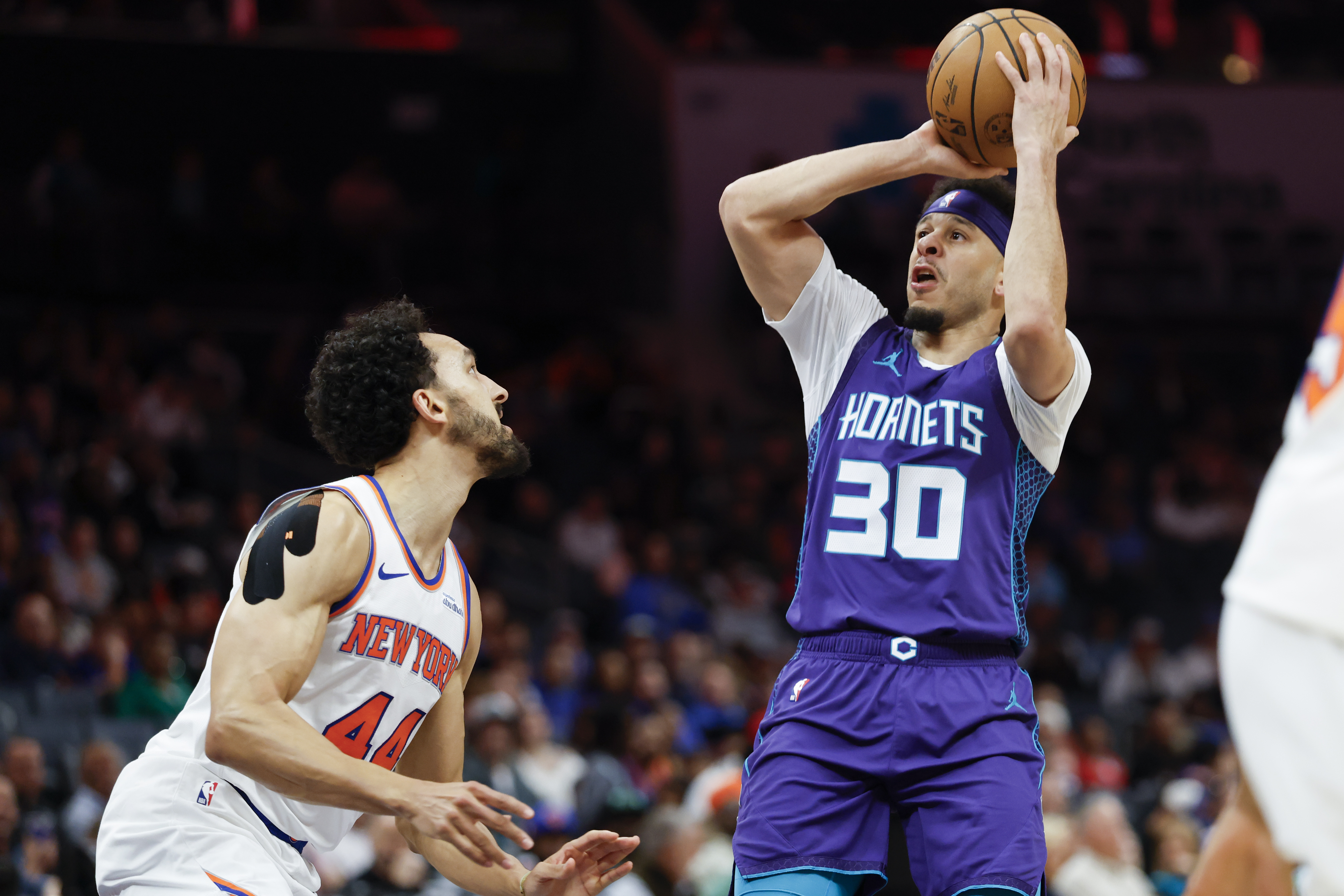 Charlotte Hornets guard Seth Curry (30) looks to shoot over New York Knicks guard Landry Shamet, left, during the first half of an NBA basketball game in Charlotte, N.C., Thursday, March 20, 2025.