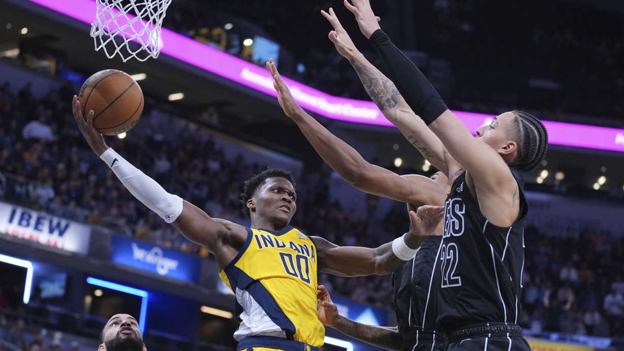 Indiana Pacers guard Bennedict Mathurin (00) makes a pass around Brooklyn Nets forward Jalen Wilson (22) during the second half of an NBA basketball game in Indianapolis, Thursday, March 20, 2025.